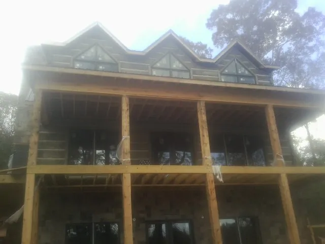Dormers and porch framing on a large log home under construction — Roof Coating work by our crew in Kalama